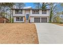 Charming two-story home with a wide driveway leading to a two-car garage and a yard awaiting landscape at 5331 Woodbin Dr, Norcross, GA 30093