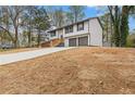 Charming two-story home with a wide driveway leading to a two-car garage and a yard awaiting landscape at 5331 Woodbin Dr, Norcross, GA 30093