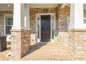 Brick front porch with white columns, brick facade and accent lighting creating a welcoming entrance at 5386 Bluestone Cir, Mableton, GA 30126