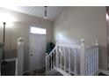 Bright foyer with staircase, neutral walls, transom window, and decorative light fixture above door at 2562 Kennesaw Springs Nw Ct, Kennesaw, GA 30144