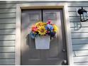 Close-up of front door featuring a beautiful floral arrangement, lantern and gray wood siding at 2562 Kennesaw Springs Nw Ct, Kennesaw, GA 30144