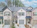 A view of charming townhomes with a well-manicured lawn, gray garage doors, and professionally landscaped lawns at 3132 Meadowstone Sw Ln, Atlanta, GA 30331