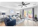 Bright living room with modern furniture, ceiling fan, and french doors to patio at 5005 Pat Mell Se Pl, Smyrna, GA 30080