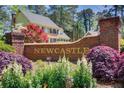 A lushly landscaped entrance sign to the Newcastle community, featuring colorful plantings at 5162 Charlemagne Sw Way, Lilburn, GA 30047