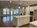 Bright living room with hardwood floors, fireplace, and kitchen island at 138 Briargate Dr, Johns Creek, GA 30097