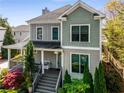 Inviting two-story home with a covered porch, lush landscaping, and a peaceful residential setting at 1324 Cambridge Ave. Sw, Atlanta, GA 30344