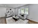Bright living room features hardwood floors, large windows, modern decor, and a comfortable seating arrangement at 1450 Cedarhurst Dr, Dunwoody, GA 30338