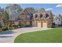 A detailed view of the home's exterior, featuring brick and stone accents, and a well-manicured lawn at 6925 Lighthouse Point, Cumming, GA 30041