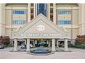 A grand entrance of 1500 Tara Place Condominiums featuring a water fountain and manicured landscaping at 1500 Tara Pl # 709, Hampton, GA 30228