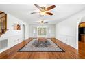 Open-concept living room with hardwood floors, ceiling fans, and a staircase at 300 Smith Ave, Bowdon, GA 30108