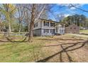 Side view of two-story home with manicured lawn and mature trees, providing shade and curb appeal at 6414 Bimini Dr, Forest Park, GA 30297