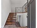 Inviting foyer with wood stairs, iron railing, and tile flooring offering a warm and stylish entrance at 6414 Bimini Dr, Forest Park, GA 30297