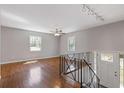 Bright living room featuring hardwood floors, large windows, and access to the staircase and front entrance at 6414 Bimini Dr, Forest Park, GA 30297