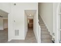 Inviting foyer with wood-look flooring, staircase, and views into the kitchen, creating a warm and welcoming entrance at 164 Edison Dr, Stockbridge, GA 30281