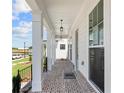 Spacious front porch with brick flooring, white columns, and pendant lighting at 532 Pearl St, Cumming, GA 30040