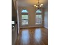 Bright dining area with hardwood floors, arched windows, and decorative chandelier at 10918 Gallier St, Alpharetta, GA 30022