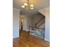 Beautiful foyer with hardwood floors, staircase, chandelier and half bath nearby at 10918 Gallier St, Alpharetta, GA 30022