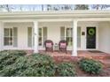 Inviting front porch with a brick floor, two chairs, and the home's address above the door at 1254 Moores Mill Nw Rd, Atlanta, GA 30327
