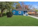 Charming blue home with a well-maintained front lawn and beautiful landscaping at 5074 Park Ave, Forest Park, GA 30297
