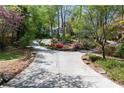 Long, curving driveway surrounded by lush landscaping and colorful azaleas leading to home at 1209 The By Ne Way, Atlanta, GA 30306