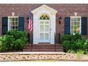 Close up view of the front door with white trim, sidelights, and a hanging American flag at 1209 The By Ne Way, Atlanta, GA 30306