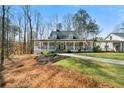 Inviting home featuring a spacious covered porch, manicured lawn, and charming curb appeal at 1064 Brooks Rackley Rd, Dallas, GA 30157