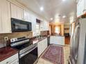 Spacious kitchen featuring white cabinetry, stainless appliances, tile backsplash, and tile floor at 2567 Connally Dr, East Point, GA 30344