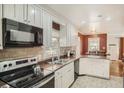 Well-lit kitchen with stainless sink, white cabinets, tile backsplash, and tile floors at 2567 Connally Dr, East Point, GA 30344