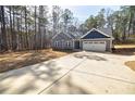 Lovely gray home featuring a long driveway, two-car garage, and inviting curb appeal at 5328 Monticello Dr, Villa Rica, GA 30180