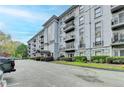 Multi-story condo building with balconies, well-maintained landscaping, and parking in front, offering a sophisticated urban living experience at 3201 Lenox Rd Ne # 13, Atlanta, GA 30324
