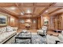 Elegant living room featuring coffered ceilings, wood paneling, sophisticated furniture, and a vintage luggage cart at 3201 Lenox Rd Ne # 13, Atlanta, GA 30324