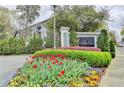 Community entrance with 'The James' signage, mature trees, vibrant flowers, and manicured landscaping creating an inviting first impression at 3201 Lenox Rd Ne # 13, Atlanta, GA 30324