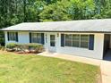 Picture-perfect single-story home with fresh paint, dark shutters, and a lush green lawn at 663 Embry Ln, Marietta, GA 30066