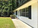 Side view of a renovated single-story home with a well-manicured lawn and modern shutters at 663 Embry Ln, Marietta, GA 30066