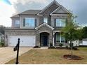 Charming two-story home with a stone and brick facade and well-manicured lawn at 7665 Easton Valley Ln, Cumming, GA 30028