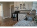 Modern kitchen with white cabinets, granite countertops, and stainless-steel appliances at 8424 Taylor Rd, Riverdale, GA 30274
