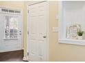 Bright hallway with a decorative shelf with decorative niche and a door to the outside at 5965 Ellington Cv, Cumming, GA 30040