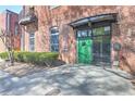 Close up of brick building entrance with green door, metal awning, and small landscaped area at 350 Peters Sw St # 19, Atlanta, GA 30313