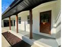 Inviting front entrance with a wooden door, white brick, and dark wood columns at 4651 S Roberts Drive, Sugar Hill, GA 30518