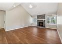 Bright living room with a stone fireplace, hardwood floors, and two windows for natural light at 1870 Abercorn Way, Snellville, GA 30078