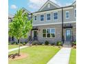 Attractive brick townhome with a tidy green lawn, concrete path, and welcoming front entrance at 1260 Ainsworth Aly # 47, Sugar Hill, GA 30518