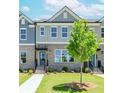 Inviting townhome with brick facade, neat landscaping, and clear walkway under a sunny sky at 1260 Ainsworth Aly # 47, Sugar Hill, GA 30518