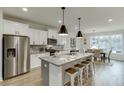 Bright kitchen features a large island with bar seating, stainless steel appliances, and modern pendant lighting at 1260 Ainsworth Aly # 47, Sugar Hill, GA 30518