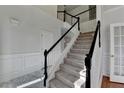 Elegant entryway staircase with black handrails, carpeted steps, and direct access to other rooms in the home at 1824 Kristen Ct, Suwanee, GA 30024