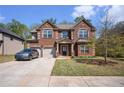 Inviting two-story brick home featuring a well-manicured lawn, a two-car garage, and a welcoming facade at 5761 Sawgrass Cir, Lithonia, GA 30038