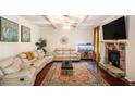 Spacious living room featuring a stone fireplace, a ceiling fan, and a large area rug at 5761 Sawgrass Cir, Lithonia, GA 30038