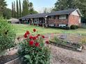 Two-story brick home with charming garden featuring red flowers and a well-manicured lawn at 2520 Robin Hood Ne Pl, Marietta, GA 30068