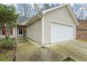Exterior view of home showcasing a two-car garage with siding and a driveway at 300 Lakeside Dr, Covington, GA 30016