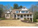 Gorgeous two-story home boasts a charming front porch, manicured lawn, and a mix of stone and siding at 3227 Aviary Nw Ct, Acworth, GA 30101