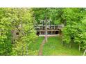 Contemporary two-story home with large windows and spacious deck, surrounded by lush greenery and mature trees at 132 Lakeshore Dr, Roswell, GA 30075